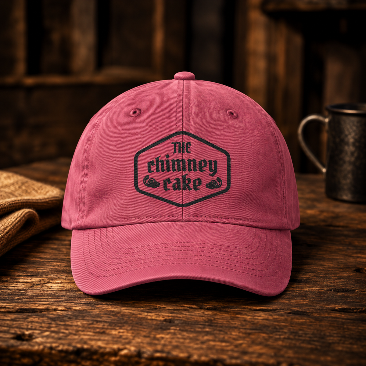 Crimson washed cotton cap with The Chimney Cake crest embroidered in dark thread