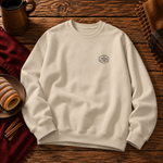 Front of the Sand sweatshirt with the small Chimney Cake badge on the left chest, beside chimney cakes and cinnamon sticks