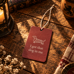 Red car air freshener on a wooden table, printed with a dachshund chimney cake above I got that dog in me